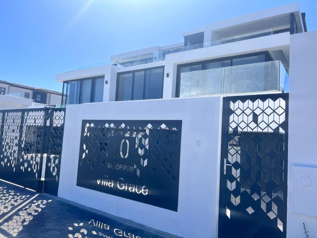 a building with a sign that reads white cottage at Villa Grace in Cape Town
