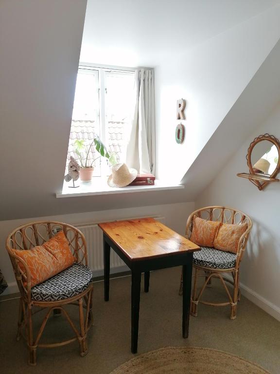 a dining room with two chairs and a table and a window at Femmasteren Hotel & Hostel in Marstal