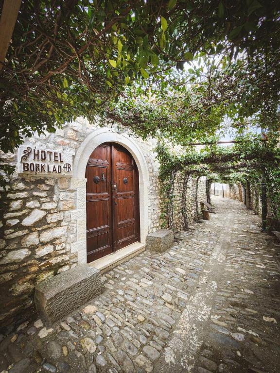 a building with a large wooden door on a street at Hotel Borklad in Berat