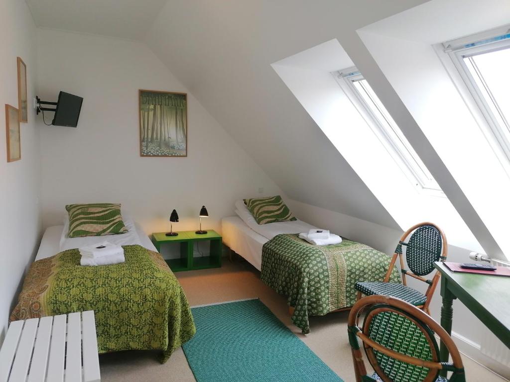 a attic bedroom with two beds and a bench at Femmasteren Hotel & Hostel in Marstal