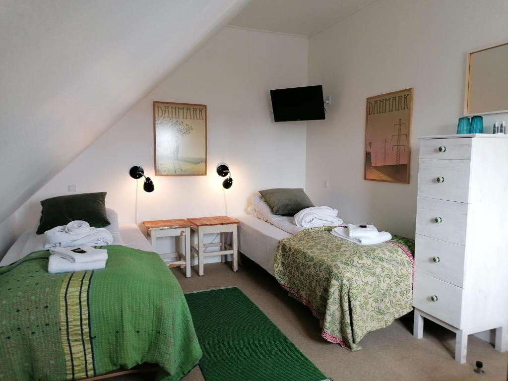 a bedroom with two beds and a dresser at Femmasteren Hotel & Hostel in Marstal