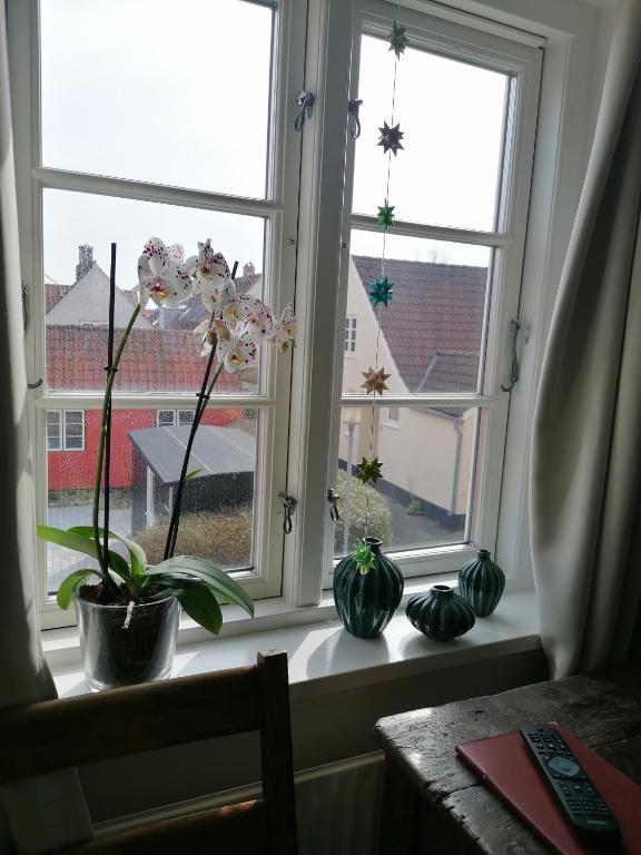 a window with three vases sitting on a window sill at Femmasteren Hotel & Hostel in Marstal