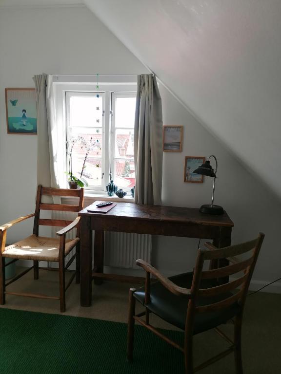 a desk and chairs in a room with a window at Femmasteren Hotel & Hostel in Marstal