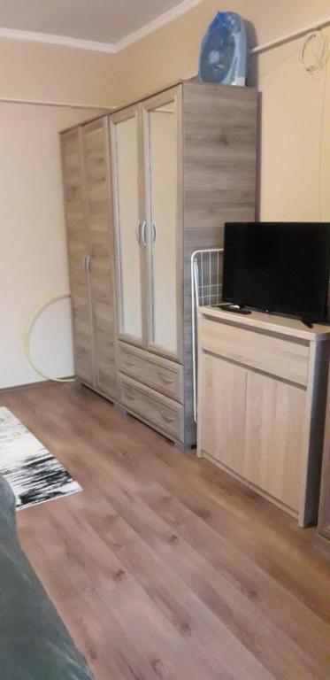 a living room with a flat screen tv on a cabinet at Pamacs Apartman in Szolnok