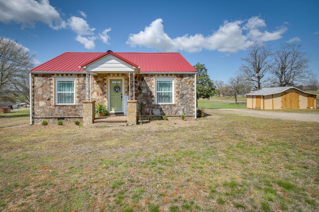 una casa de piedra con techo rojo en un campo en Quiet Subiaco Vacation Rental Near Lake Dardanelle, en Paris