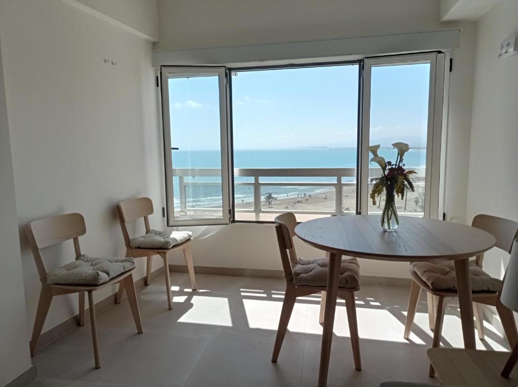 a dining room with a table and a view of the beach at Apartamento en El Prado in Cullera
