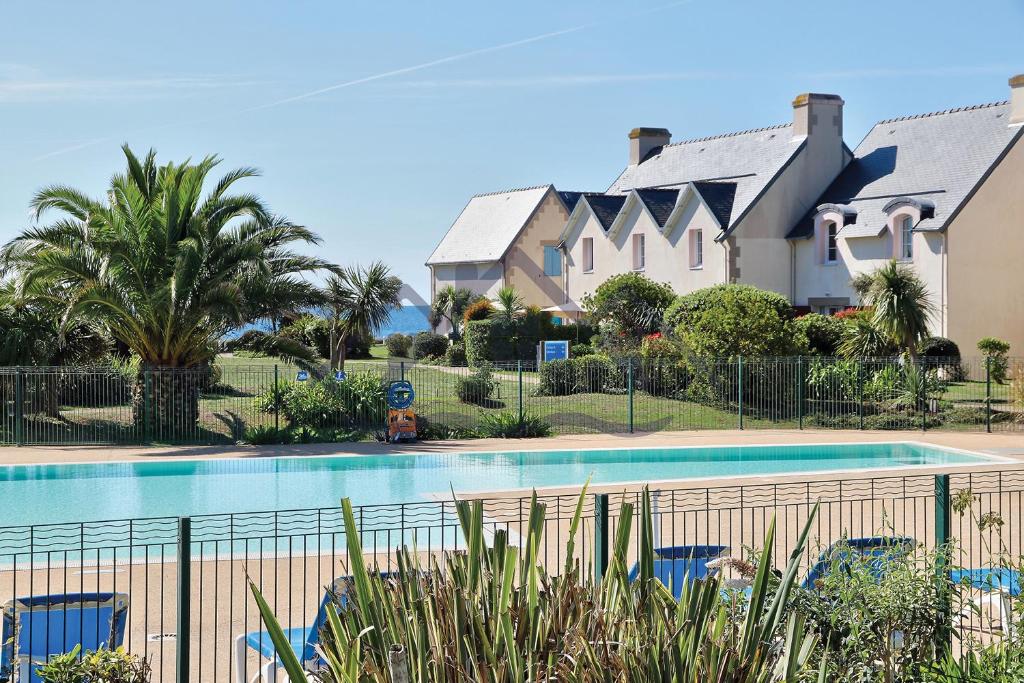 una piscina di fronte a una casa di LocaLise - A05 - Plain-pied avec petite vue mer donnant sur la piscine et le jardin - Wifi inclus - draps inclus - animaux bienvenus - parking gratuit a Le Guilvinec