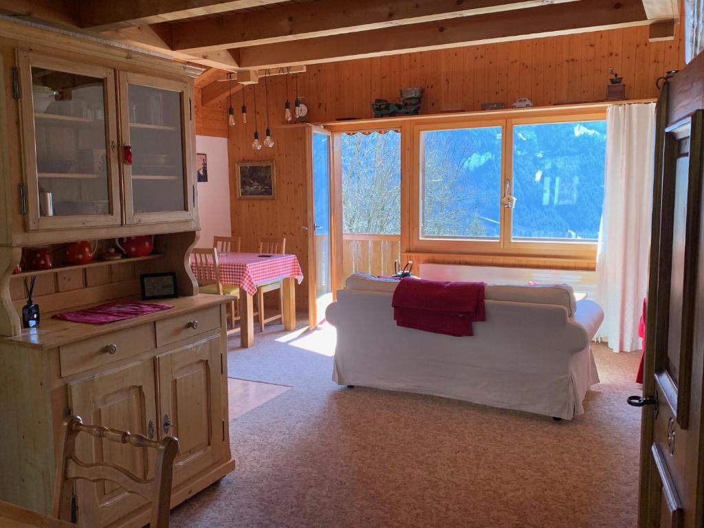 ein Wohnzimmer mit einem weißen Sofa und einer Küche in der Unterkunft Grindelwald-Sunneblick in Grindelwald