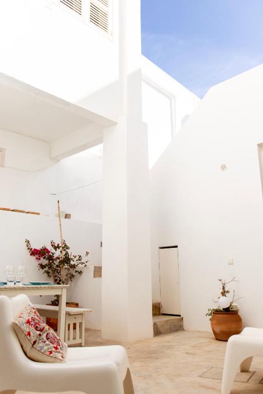 a white room with a white couch and a table at Casa do Almirante in Tavira