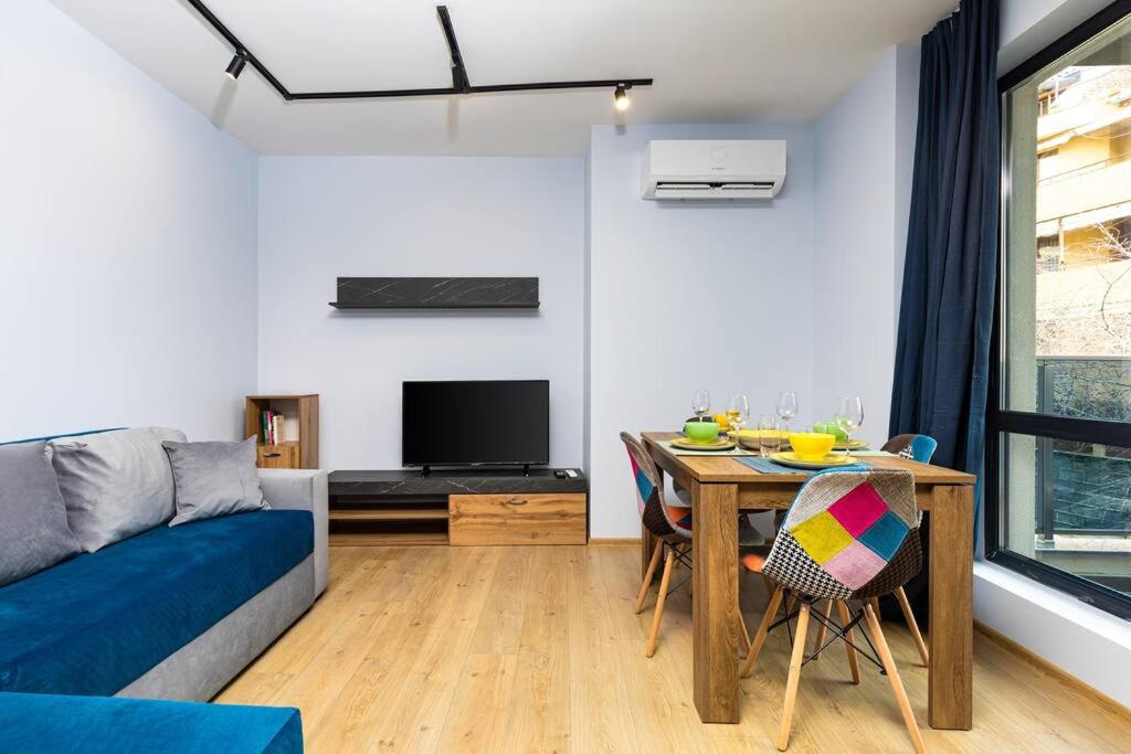 a living room with a table and a couch at Brand New Modern 1BR Apartment with Private Parking included in Plovdiv