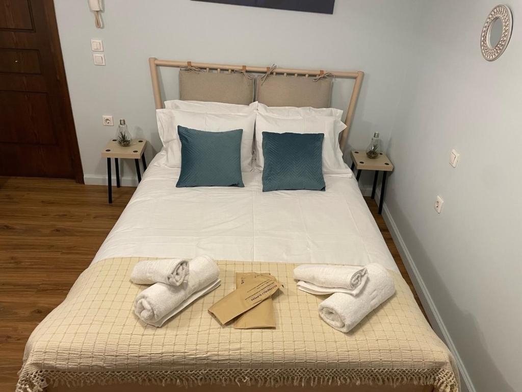 Una cama con dos pares de zapatillas y certificados. en Casa di fiore en Corfú