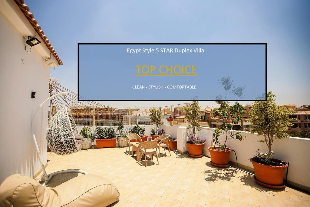 einen großen Bildschirm auf einer Terrasse mit Pflanzen in der Unterkunft Egyptian Style 5 STAR Villa for Friends and Family Gatherings in Madinat as-Sadis min Uktubar