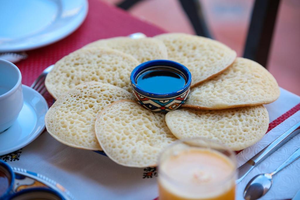 a plate of cookies with a blue bowl on top at Villa Sable de Mirleft Luxury Apartment in Mirleft