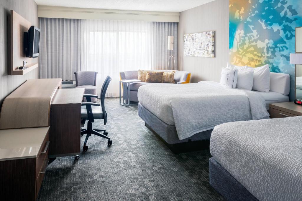 a hotel room with two beds and a desk at Courtyard Toledo Rossford/Perrysburg in Rossford