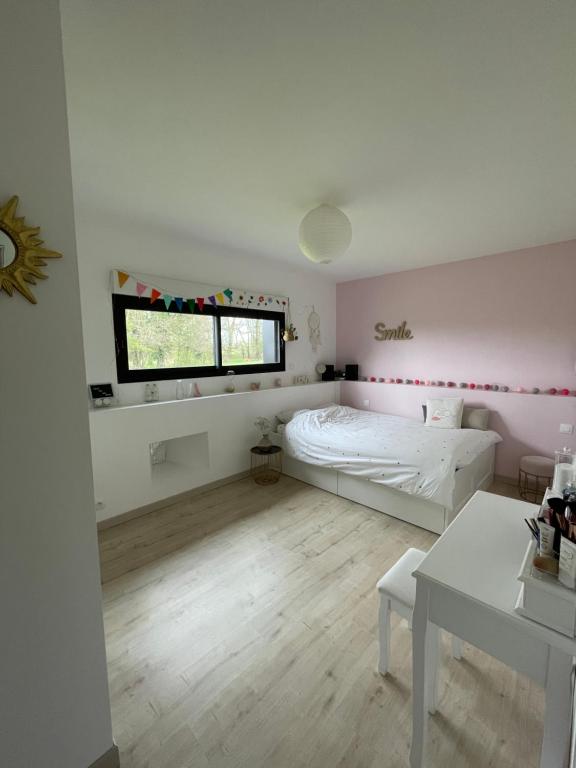 a bedroom with a bed and a window and a table at Chambres privées dans fermette rénovée proche du Mans au calme in Changé