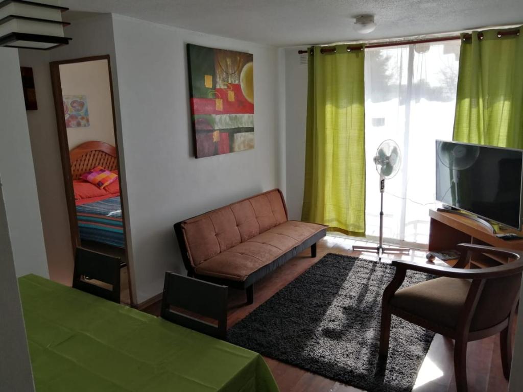 uma sala de estar com um sofá e uma televisão em Hospedaje Rancagua - Centro - Hermoso Departamento em Rancagua