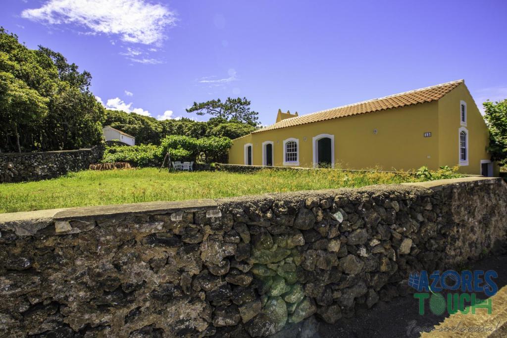 un muro di pietra di fronte a una casa di Casa do Merendário a Praia da Vitória