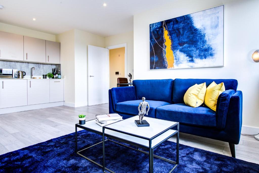 a living room with a blue couch and a table at Hybrid Resi - Cheam, Sutton in Cheam