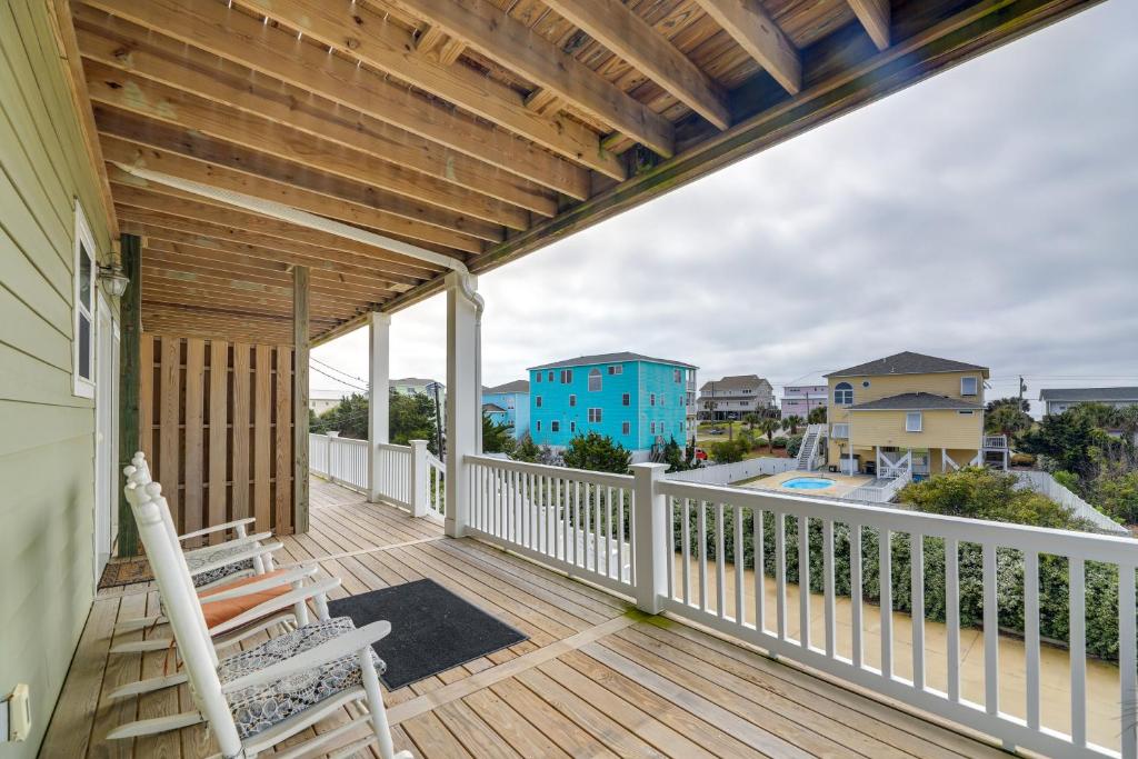 a deck with two chairs and a blue building at Pet-Friendly Emerald Isle Vacation Rental! in Emerald Isle