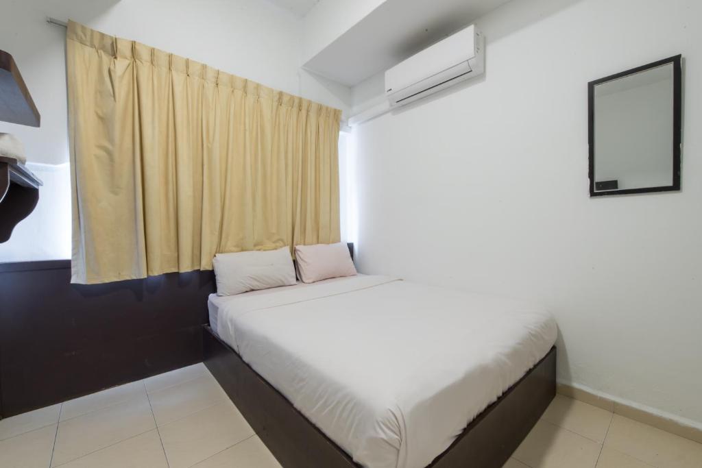 Habitación pequeña con cama y ventana en Hollitel Hotel, en Melaka