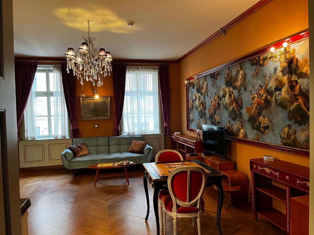 een woonkamer met een bank en een schilderij aan de muur bij Le Papillon de Bohème in Praag