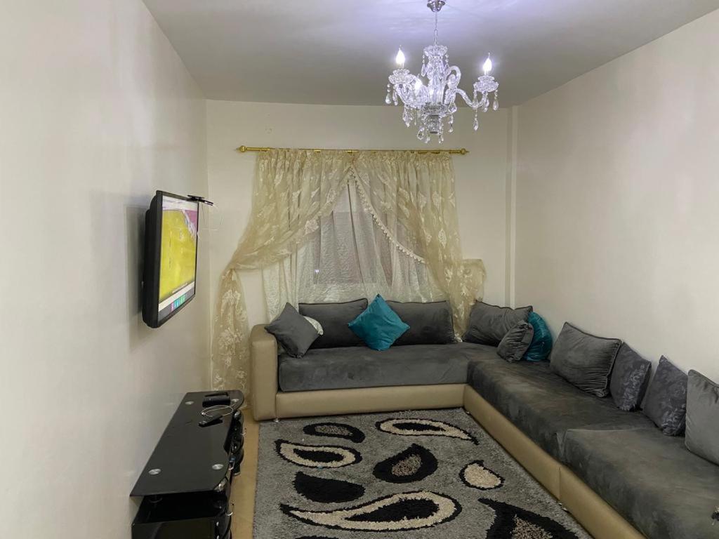 Casablanca Airport Appartement في Deroua: غرفة معيشة مع أريكة وثريا