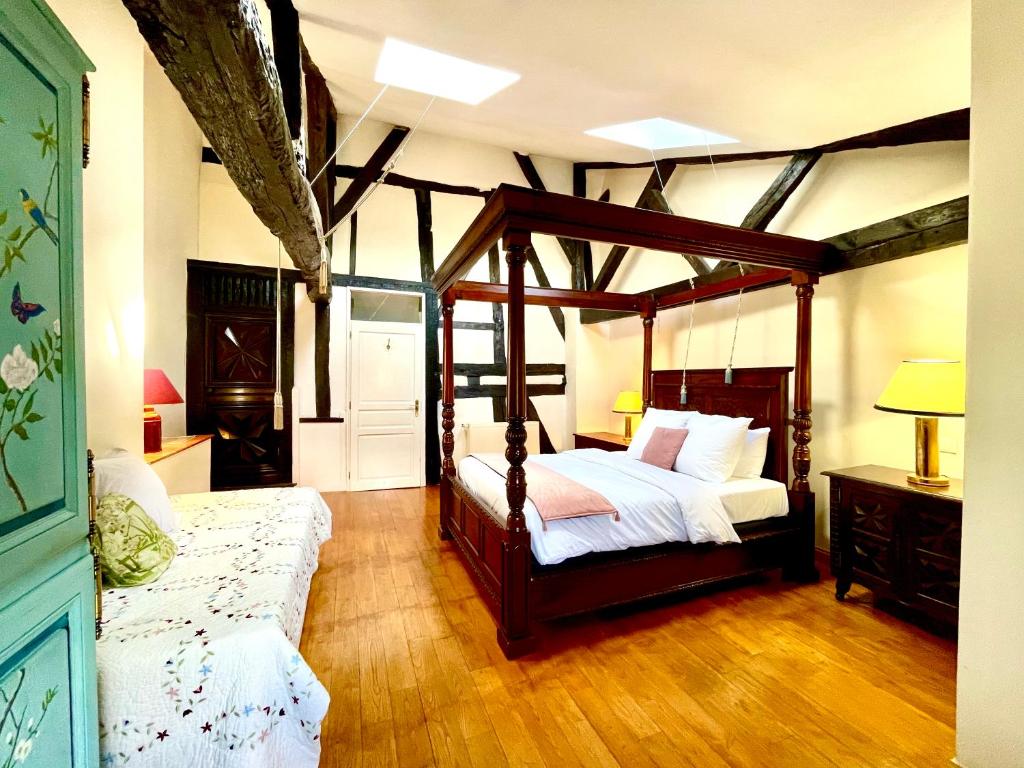 um quarto com uma cama de dossel e um sofá em Le Logis Plantagenêt em Bergerac