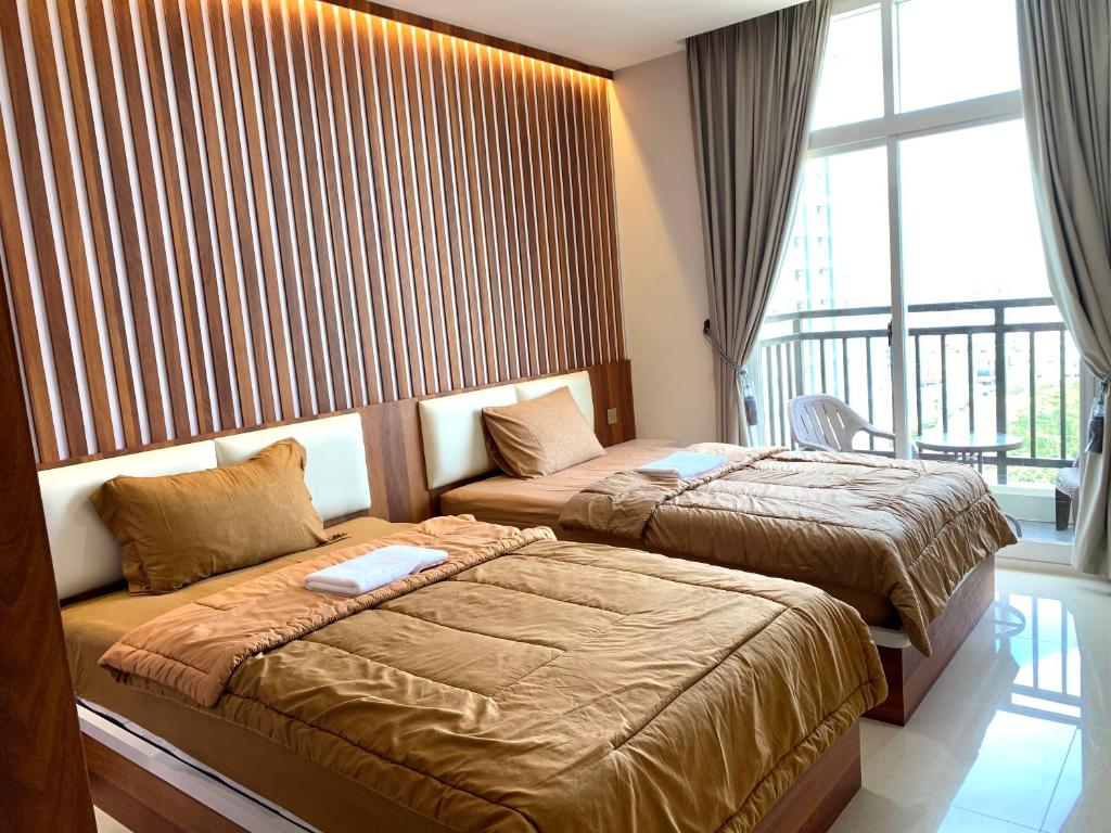 a hotel room with two beds and a window at 12-10 Twin bedroom in Formosa Residence Nagoya Batam 3 pax by Wiwi in Nagoya