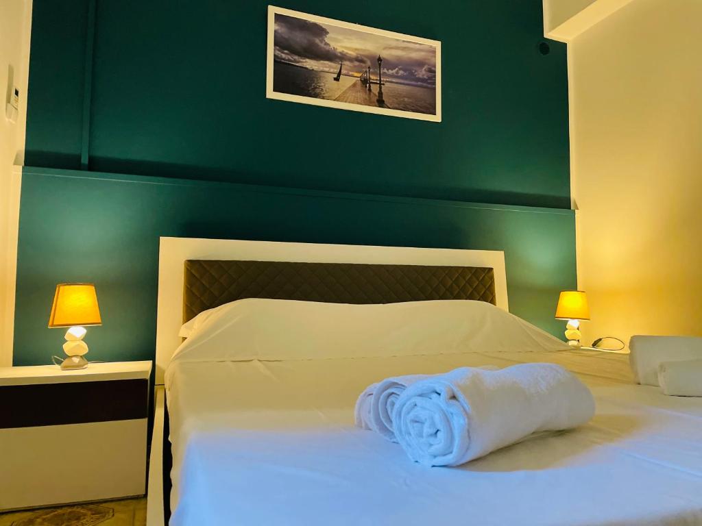 ein Schlafzimmer mit einem weißen Bett und einer grünen Wand in der Unterkunft Case Eoliane, Alicudi in Patti
