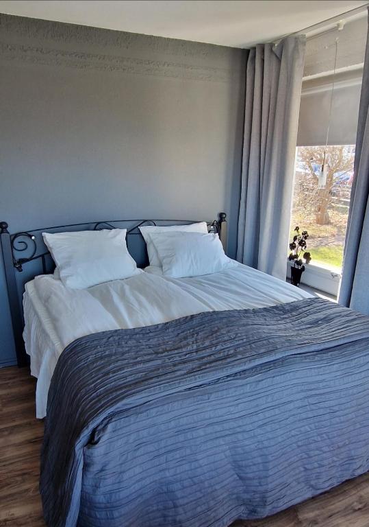 a bedroom with a large bed with a window at Lägenhet Yvonne in Gränna