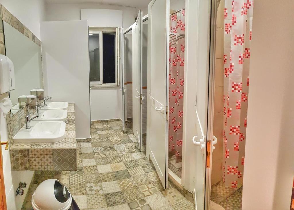 ein Bad mit 3 Waschbecken und einer Dusche in der Unterkunft Bed Station Hostel & Bar in Shkodra