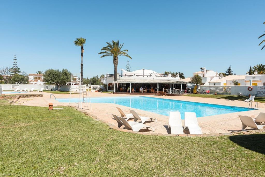a swimming pool with lounge chairs in front of a resort at Aldeia do Golfe - Private condominium by HD in Vilamoura