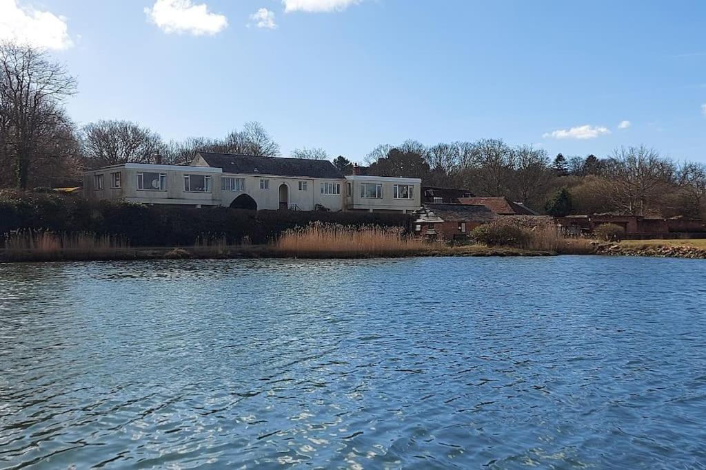 ein Haus an der Seite eines Flusses mit einem Gebäude in der Unterkunft Brooklands Farm Hamble Riverside apartment on the reiver in Southampton