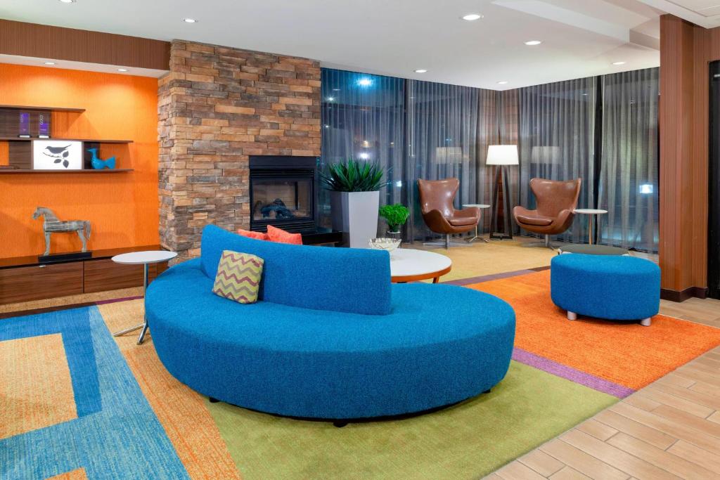 a living room with a blue couch and a fireplace at Fairfield Inn & Suites by Marriott Alamosa in Alamosa