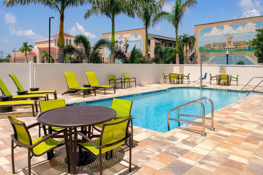 a patio with a table and chairs next to a pool at SpringHill Suites by Marriott Punta Gorda Harborside in Punta Gorda