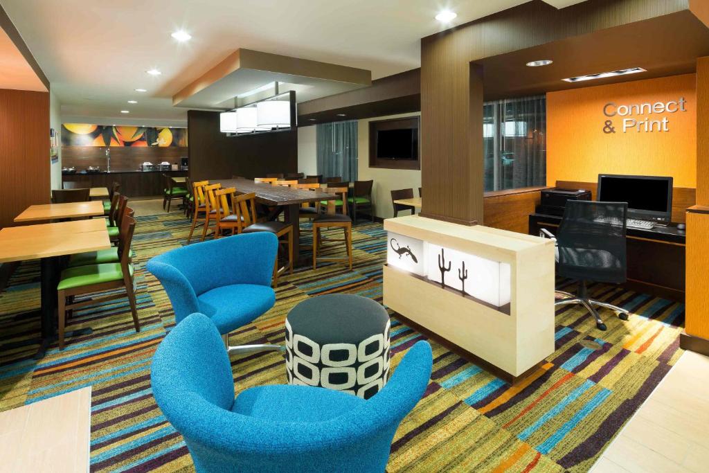 a lobby with blue chairs and a dining room at Fairfield Inn & Suites by Marriott San Antonio Airport/North Star Mall in San Antonio