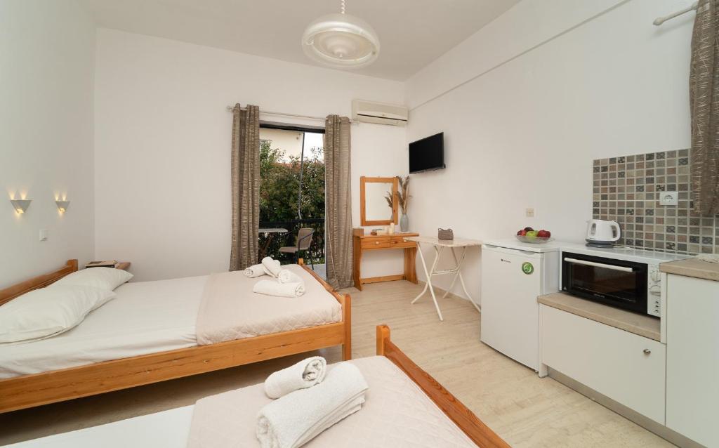 a small bedroom with a bed and a kitchen at Tsimiklis Apartments in Finikounta