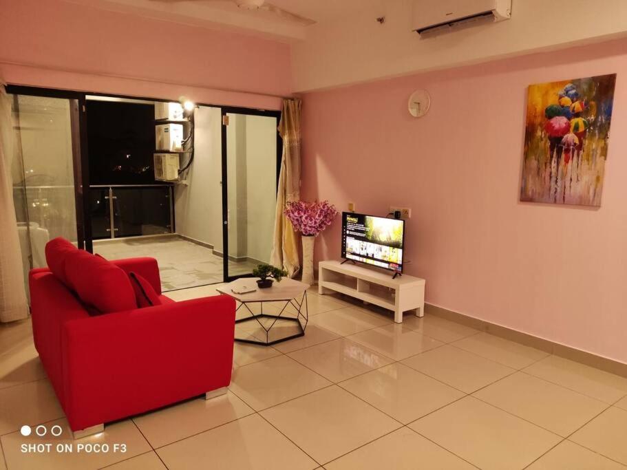 a living room with a red chair and a tv at HP402- Two Bedroom Apartment- Wifi- Netflix- Parking- Cyberjaya -New, 3061 in Cyberjaya