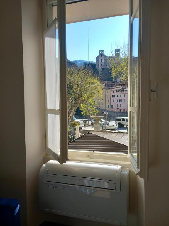 ein offenes Fenster mit Heizung und Blick auf ein Gebäude in der Unterkunft Appartamentino - Castle view, no stairs in Dolceacqua