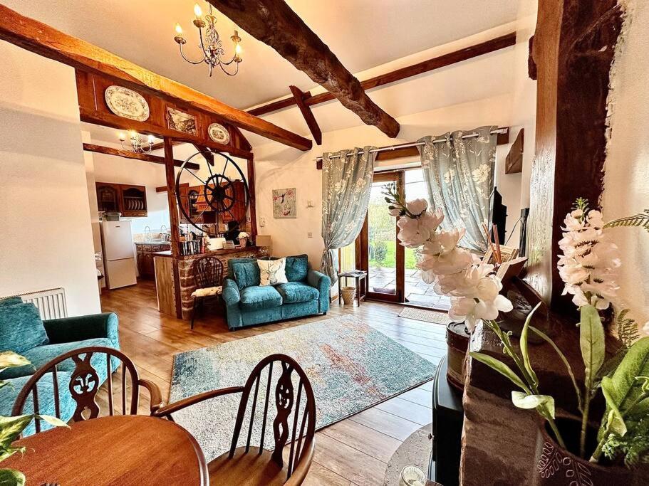 Llangwm-isaf的住宿－Detached ONE LEVEL stone barn (Rowan Cottage)，客厅配有蓝色的沙发和桌子