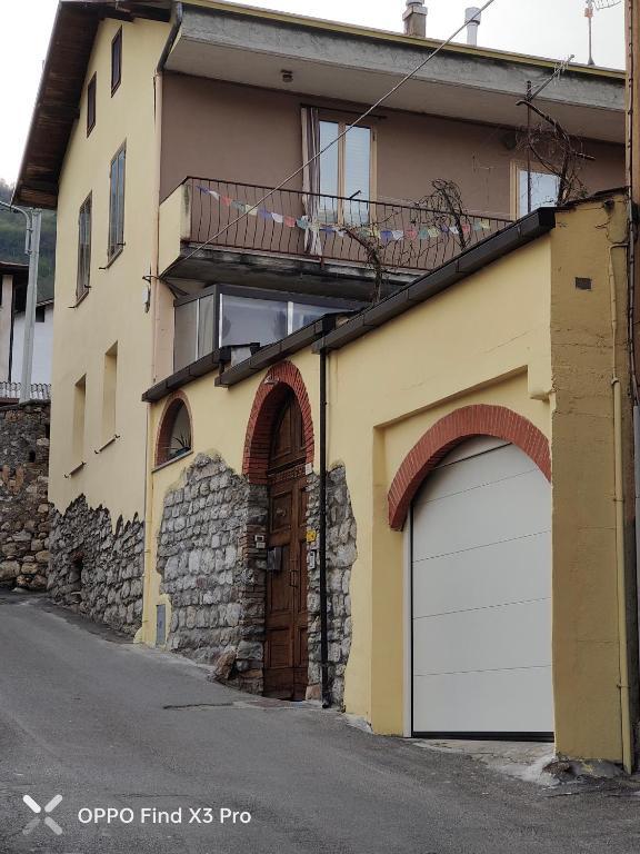 un edificio con 2 puertas de garaje y balcón en Ca del tita, en Capo di Ponte