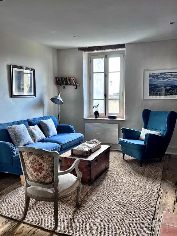 a living room with a blue couch and chairs at Maison Marie in Lagarde