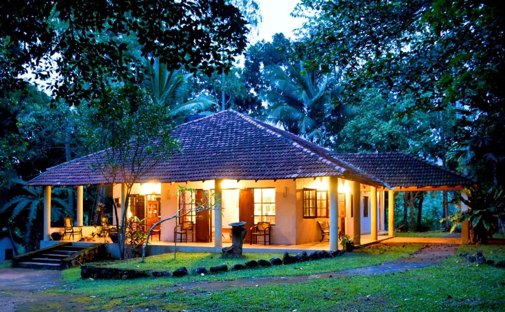 una pequeña casa con luces en la parte delantera en Captain's Bungalow, Kandy en Arawwawala