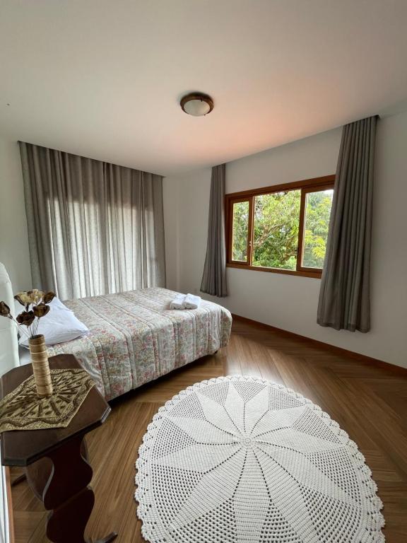 - une chambre avec un lit, une table et une fenêtre dans l'établissement Suítes no Paraíso, à Espera Feliz