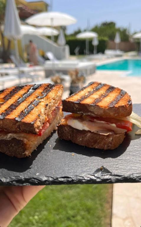two sandwiches sitting on a table next to a pool at Il Leone Di Mare in Procida