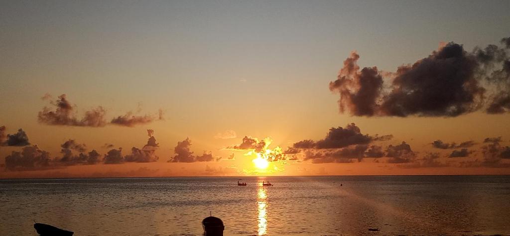 a sunset over the water with the sun in the sky at Villa Sunshine House ZANZIBAR in Jambiani