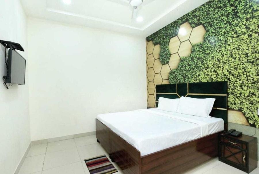 ein Schlafzimmer mit einem Bett mit einer Blumenwand in der Unterkunft OYO Hotel Golden Crown in Rājpura