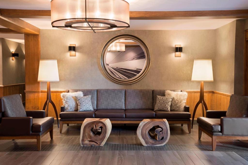 a living room with a couch and a mirror at Residence Inn by Marriott Mont Tremblant Manoir Labelle in Mont-Tremblant