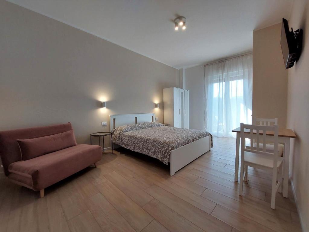 a bedroom with a bed and a couch and a chair at Ricomincio da Polignano in Polignano a Mare