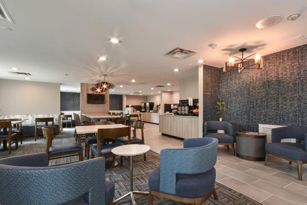 a restaurant with blue chairs and tables and a bar at Fairfield Inn & Suites Charlotte Arrowood in Charlotte
